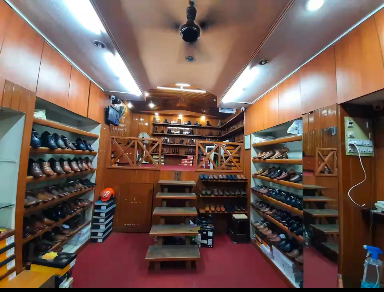Interior of the Cowboys Shoes showroom in Surat with wooden shelves of leather boots